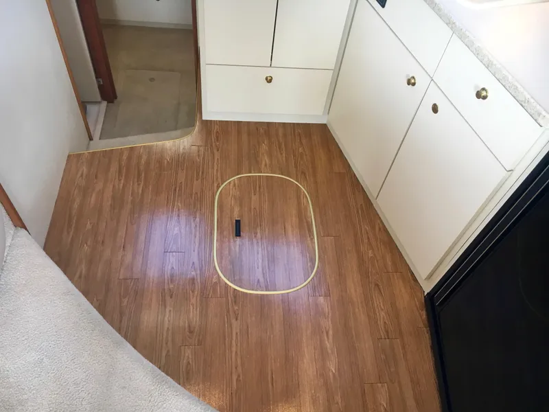 Slide: The Image of Interior of a 1999 Silverton 351 Sedan with wood flooring and white cabinets. - 21