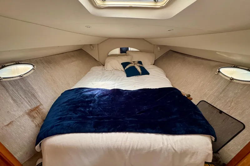 Slide: The Image of Cozy cabin interior of 1999 Silverton 351 Sedan with bed and portholes. - 23