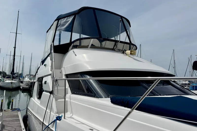 Slide: The Image of 1999 Silverton 351 Sedan yacht docked at marina, featuring sleek design and spacious flybridge. - 3