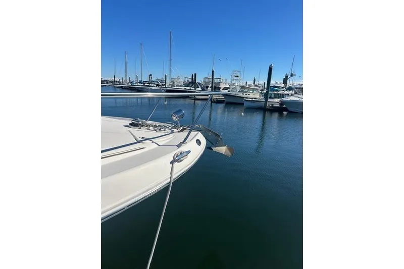 Slide: The Image of 2002 Sea Ray Sundancer 310 yacht docked in a marina under clear blue skies. - 11