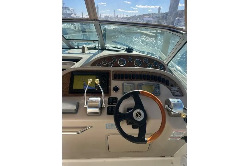 Slide: The Image of Helm of 2002 Sea Ray Sundancer 310 with steering wheel and navigation controls. - 12