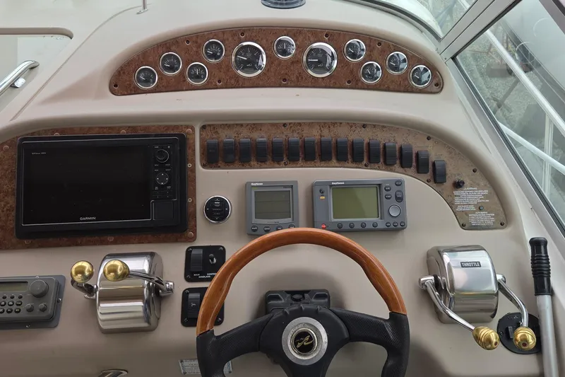 Slide: The Image of 2002 Sea Ray Sundancer 310 helm with gauges, controls, and navigation equipment. - 13