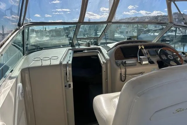 Slide: The Image of 2002 Sea Ray Sundancer 310 cockpit with steering wheel, controls, and marina view. - 17