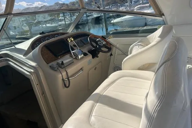 Slide: The Image of 2002 Sea Ray Sundancer 310 helm with white seating and marina view. - 18