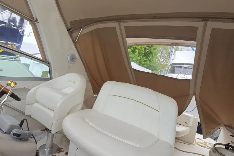 Slide: The Image of Interior of 2002 Sea Ray Sundancer 310 with white seating and brown canopy. - 21