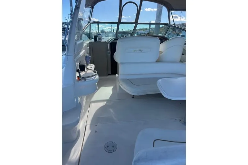 Slide: The Image of 2002 Sea Ray Sundancer 310 boat interior with white seating and helm station. - 24
