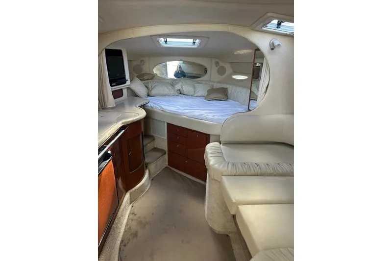 Slide: The Image of Interior of 2002 Sea Ray Sundancer 310, featuring cozy bed and elegant wood cabinetry. - 29