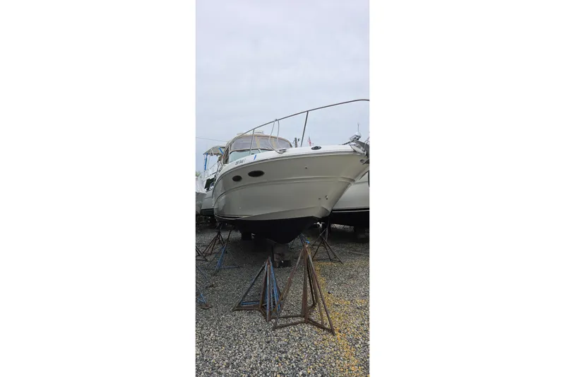 Slide: The Image of 2002 Sea Ray Sundancer 310 boat on stands in a gravel yard. - 3