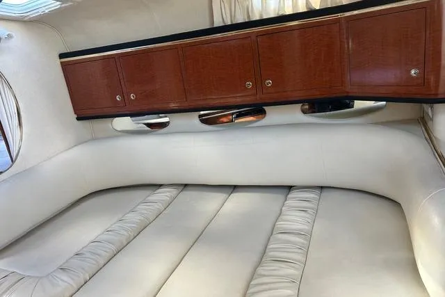 Slide: The Image of Interior of 2002 Sea Ray Sundancer 310 with white seating and wooden cabinets. - 32