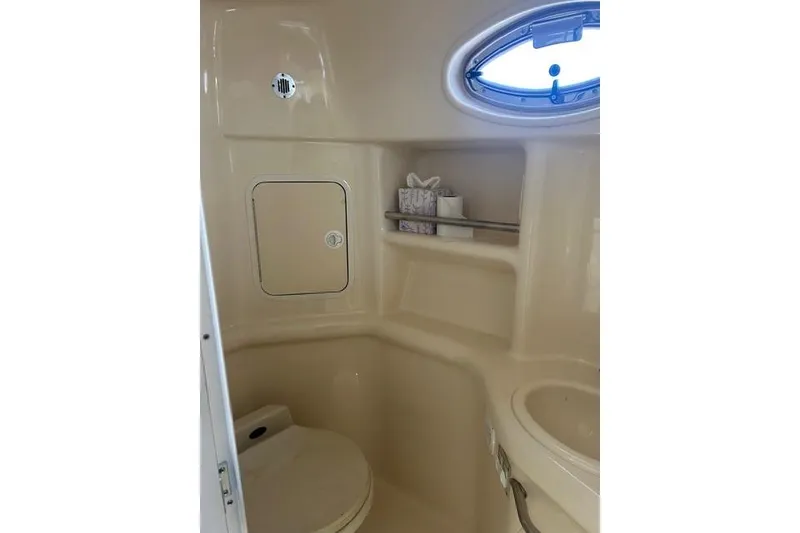 Slide: The Image of 2002 Sea Ray Sundancer 310 bathroom interior with toilet, sink, and storage shelves. - 39