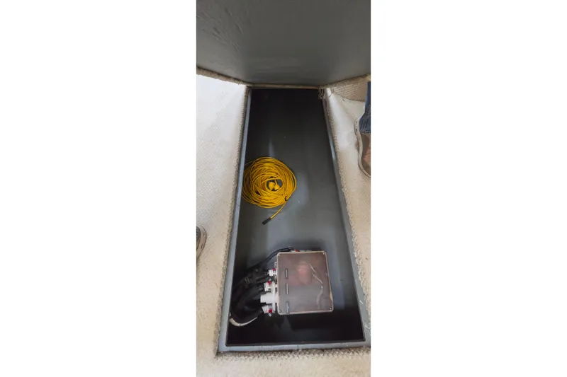 Slide: The Image of Storage compartment in a 2002 Sea Ray Sundancer 310 with coiled yellow rope and equipment. - 45