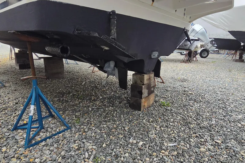 Slide: The Image of 2002 Sea Ray Sundancer 310 boat on blocks, under maintenance on gravel surface. - 6