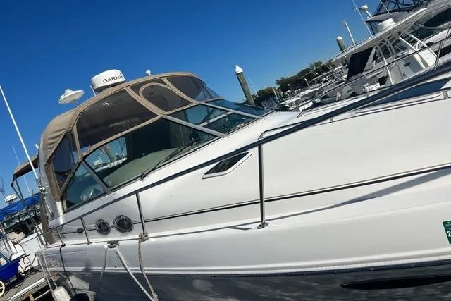 Slide: The Image of 2002 Sea Ray Sundancer 310 yacht docked at marina under clear blue sky. - 9