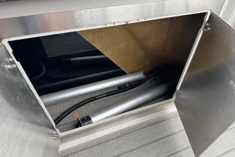 Slide: The Image of Open storage compartment in 2023 Starcraft MX 25 DL DH boat, showing interior components. - 13