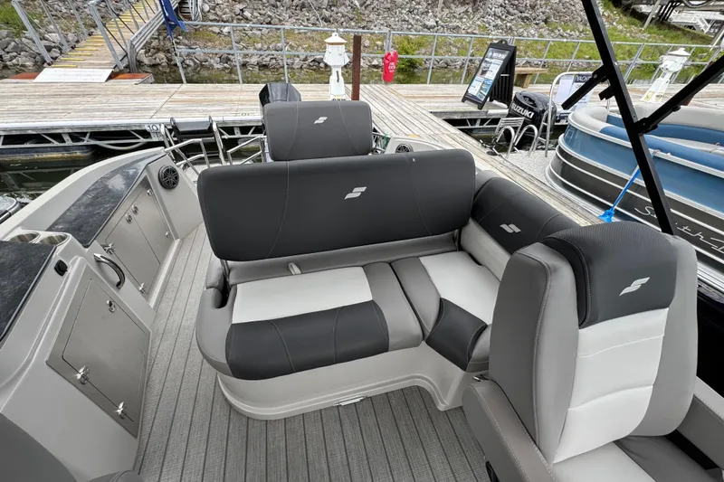 Slide: The Image of 2023 Starcraft MX 25 DL DH boat interior with gray seating at a dock. - 15