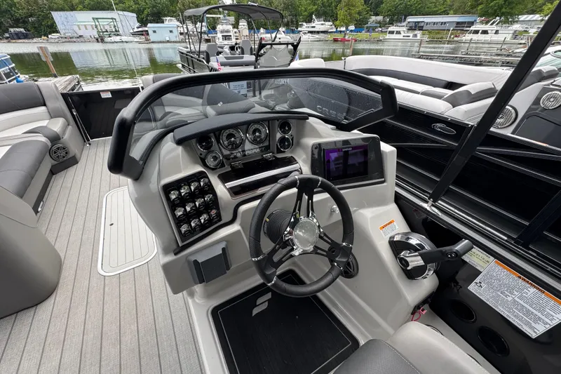 Slide: The Image of 2023 Starcraft MX 25 DL DH boat dashboard with steering wheel and control panel. - 19