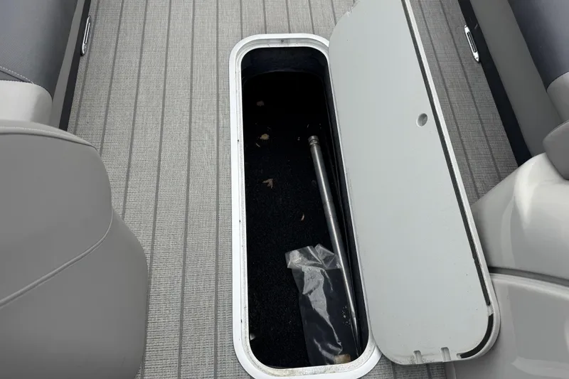 Slide: The Image of Open storage compartment on 2023 Starcraft MX 25 DL DH boat, revealing interior space. - 25