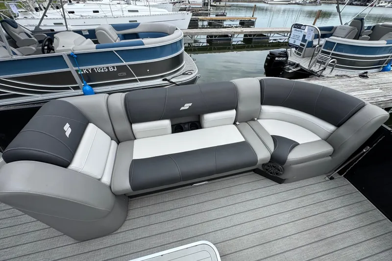Slide: The Image of 2023 Starcraft MX 25 DL DH pontoon boat with luxurious seating at a marina. - 26