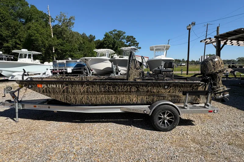 Slide: The Image of 2022 Prodigy 18' PRO VS boat with camouflage design on a trailer, parked outdoors. - 4