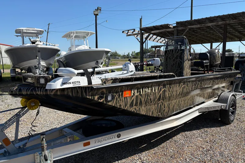 Slide: The Image of 2022 Prodigy 18' PRO VS boat with camo design on a trailer, featuring Minn Kota motor. - 6