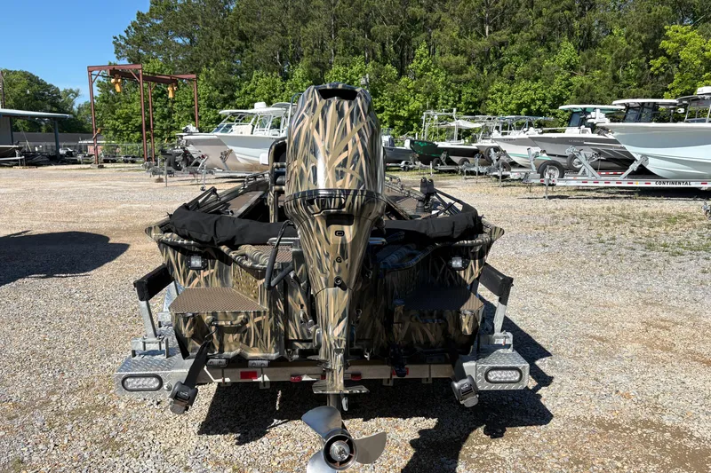 Slide: The Image of 2022 Prodigy 18' PRO VS boat with camouflage design in a boatyard setting. - 8
