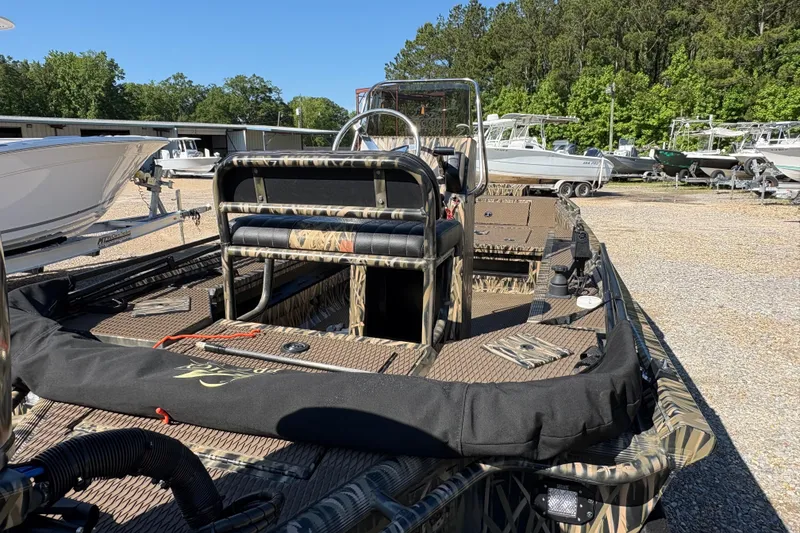 Slide: The Image of 2022 Prodigy 18' PRO VS boat with camouflage design, parked outdoors near other boats. - 9