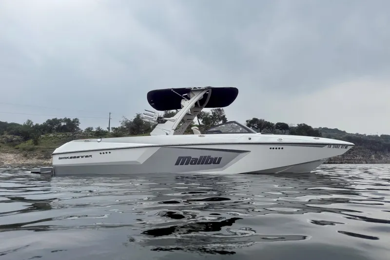 The Image of 2023 Malibu Wakesetter 24 MXZ boat on calm water, overcast sky. - 1