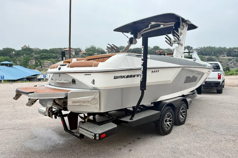 Slide: The Image of 2023 Malibu Wakesetter 24 MXZ boat on trailer, showcasing sleek design and modern features. - 10