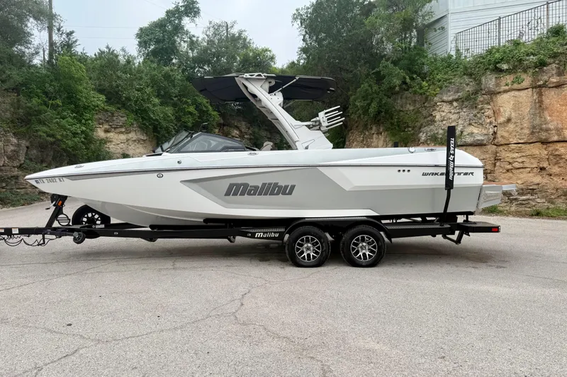 Slide: The Image of 2023 Malibu Wakesetter 24 MXZ boat on trailer, parked outdoors. - 12