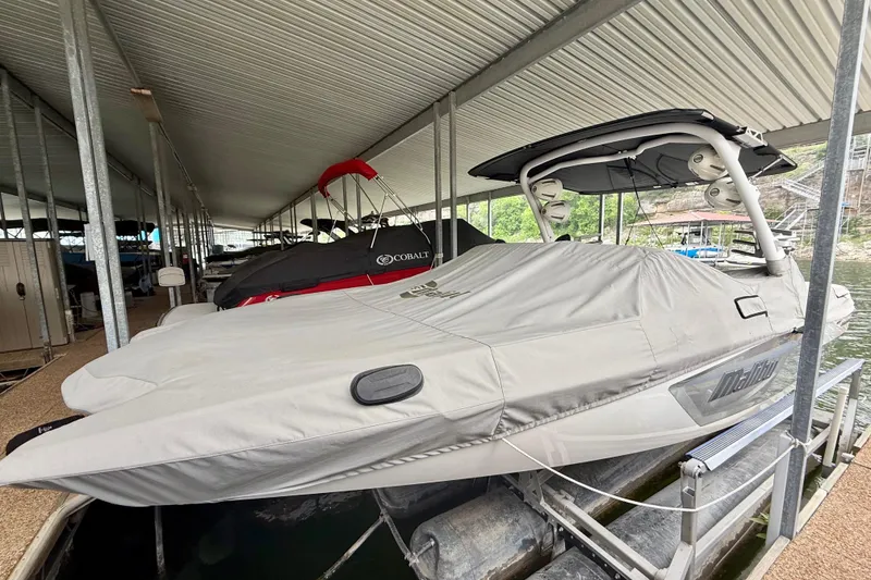 Slide: The Image of 2023 Malibu Wakesetter 24 MXZ covered in a docked marina setting. - 14