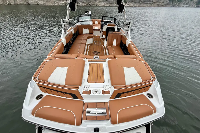 Slide: The Image of 2023 Malibu Wakesetter 24 MXZ boat with luxurious tan seating on a serene lake. - 18