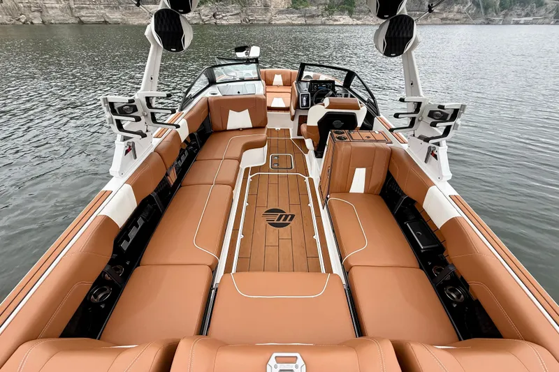 Slide: The Image of 2023 Malibu Wakesetter 24 MXZ interior with luxurious tan seating on a serene lake. - 19