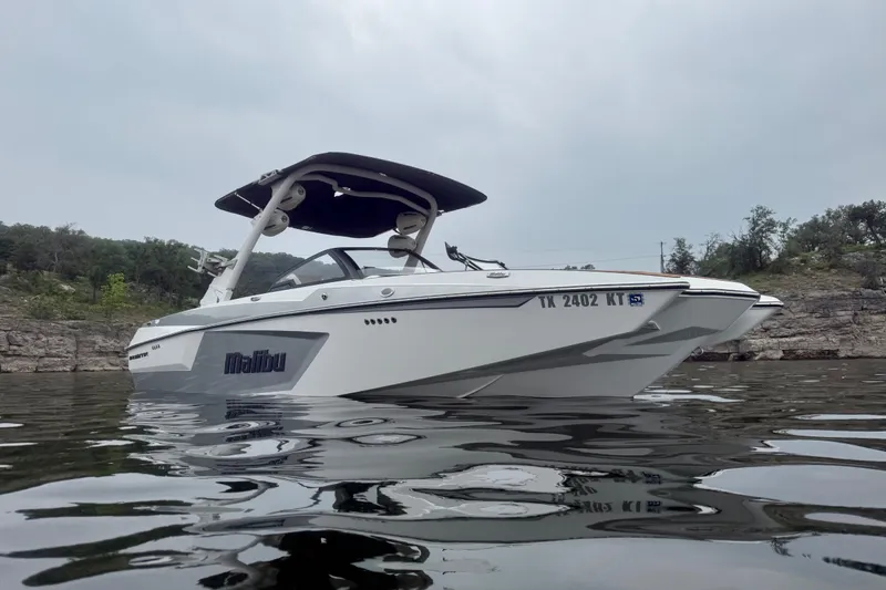 The Image of 2023 Malibu Wakesetter 24 MXZ boat on calm water, overcast sky. - 2