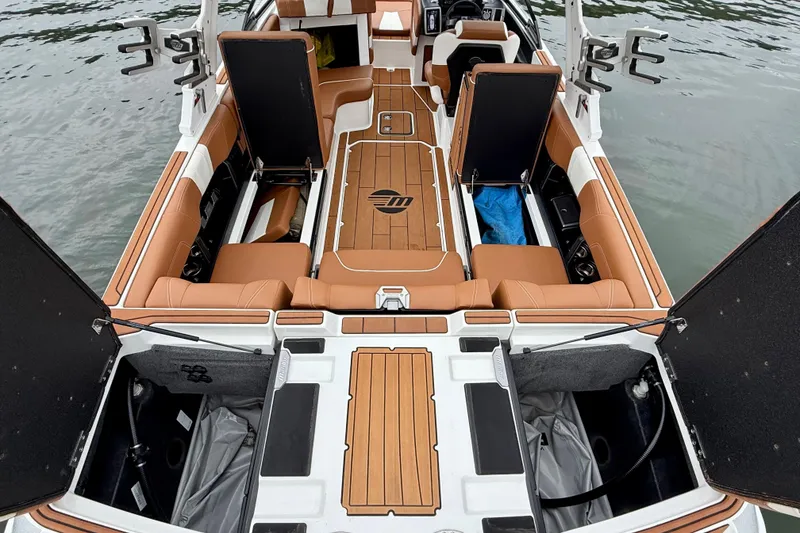 Slide: The Image of 2023 Malibu Wakesetter 24 MXZ interior with open storage compartments on water. - 28