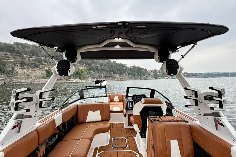 Slide: The Image of 2023 Malibu Wakesetter 24 MXZ interior with luxurious seating and advanced features on a serene lake. - 30
