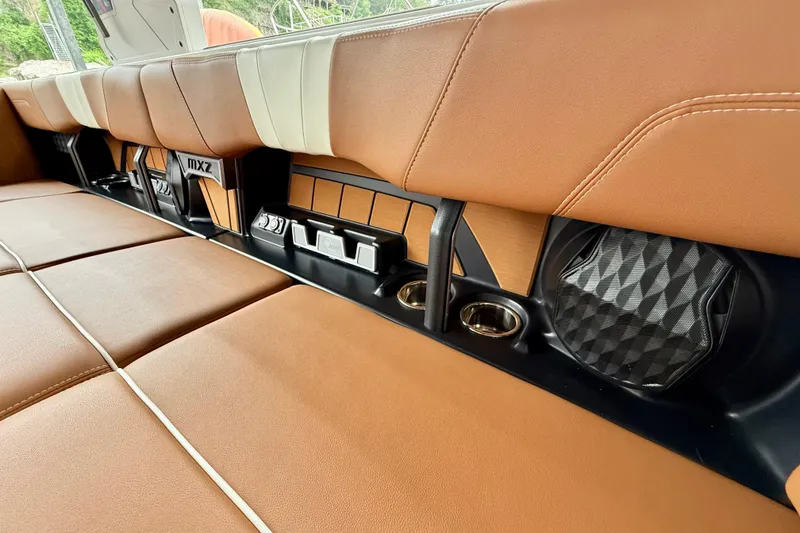 Slide: The Image of 2023 Malibu Wakesetter 24 MXZ interior with tan leather seats and built-in speakers. - 32