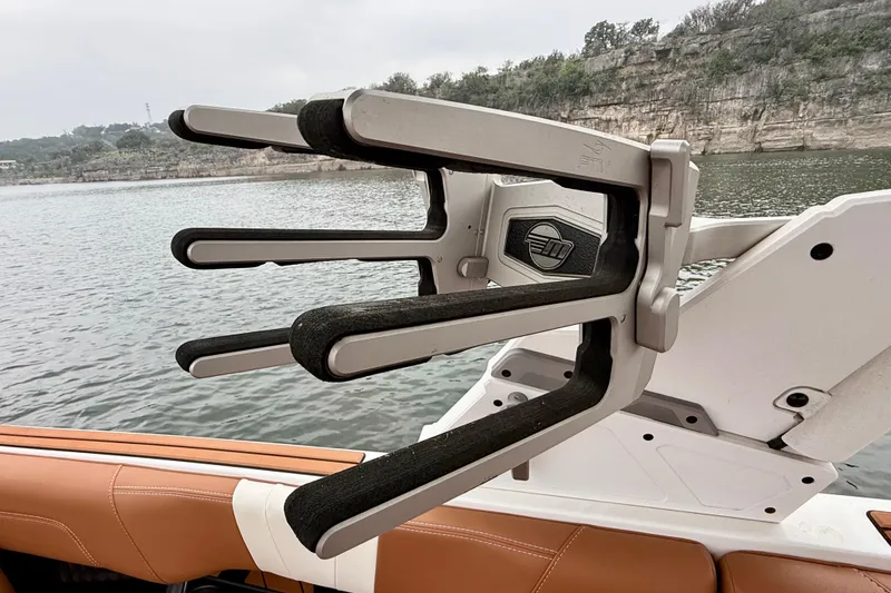 Slide: The Image of 2023 Malibu Wakesetter 24 MXZ wakeboard rack on a lake with rocky shoreline. - 35