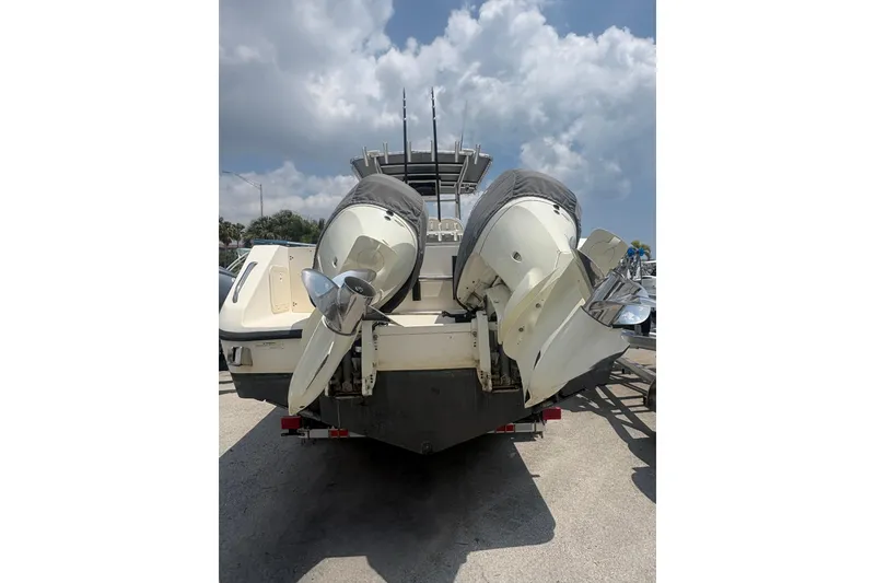 Slide: The Image of 1998 Pursuit 2870 Center Console boat with dual outboard motors, parked under a cloudy sky. - 10