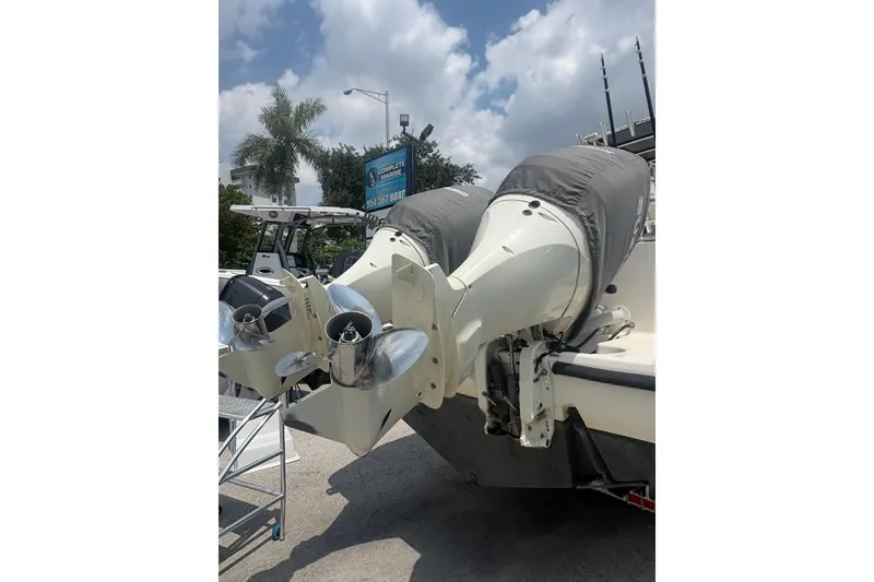Slide: The Image of 1998 Pursuit 2870 Center Console boat with dual outboard motors, parked outdoors. - 11