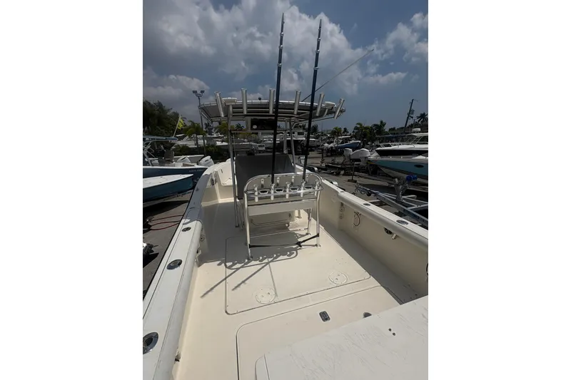 Slide: The Image of 1998 Pursuit 2870 Center Console boat with fishing rods, docked under cloudy sky. - 14