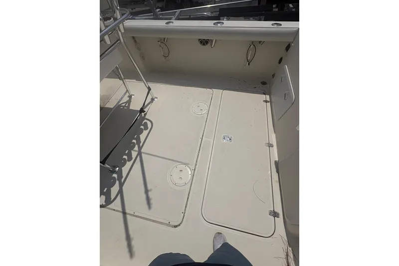 Slide: The Image of 1998 Pursuit 2870 Center Console boat deck with storage compartments and rod holders. - 16