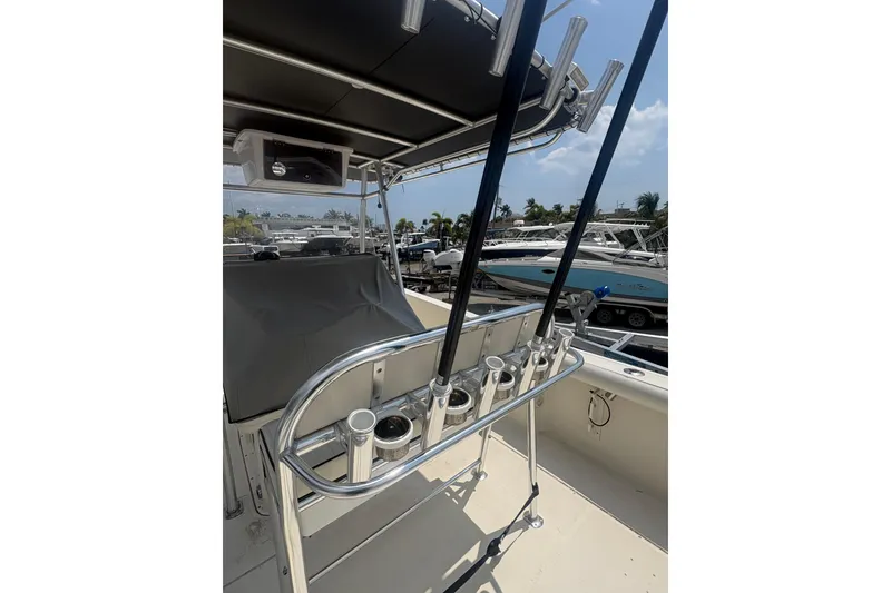 Slide: The Image of 1998 Pursuit 2870 Center Console boat with rod holders and covered seating area. - 17