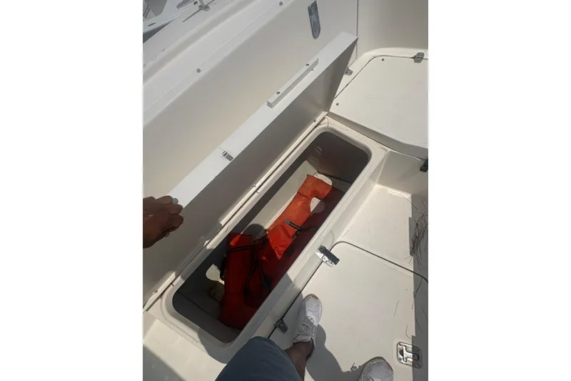 Slide: The Image of Open storage compartment on 1998 Pursuit 2870 Center Console boat with life jacket inside. - 21