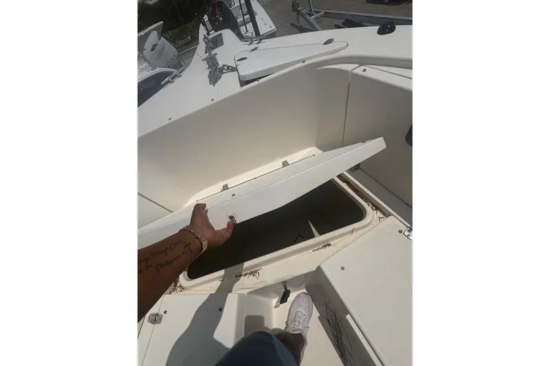 Slide: The Image of 1998 Pursuit 2870 Center Console boat storage compartment being opened. - 23