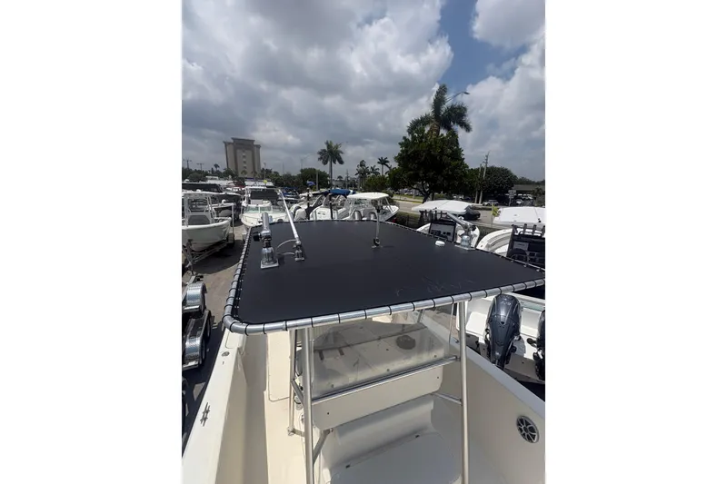 Slide: The Image of 1998 Pursuit 2870 Center Console boat with T-top, parked among other boats under cloudy skies. - 25