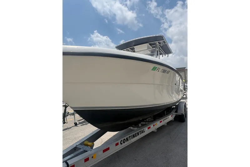 Slide: The Image of 1998 Pursuit 2870 Center Console boat on trailer under a partly cloudy sky. - 4