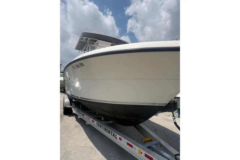 Slide: The Image of 1998 Pursuit 2870 Center Console boat on trailer under cloudy sky. - 6