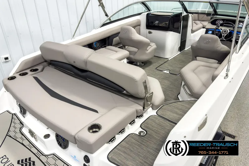 Slide: The Image of 2025 Four Winns HD3 boat interior with gray seating, modern dashboard, and cup holders. - 12