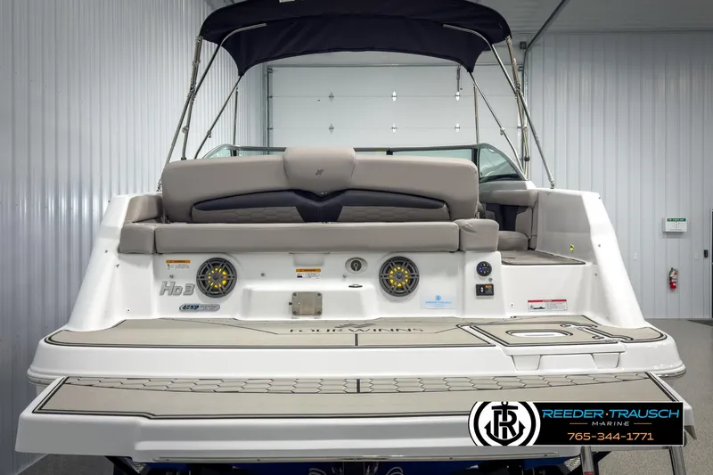 Slide: The Image of 2025 Four Winns HD3 boat interior with cushioned seating and modern design in a showroom. - 7