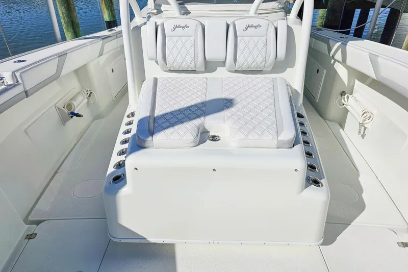 Slide: The Image of 2015 Yellowfin 42 Offshore boat interior with cushioned seating and rod holders. - 12